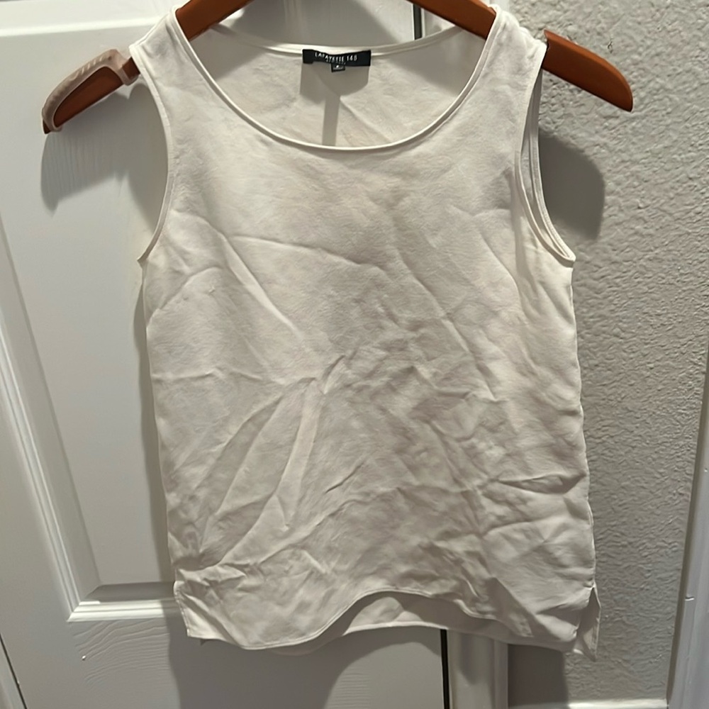 Cream tank top with side slits.
